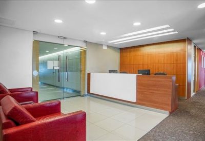 Professional reception desk with wood paneling and red leather guest chairs.