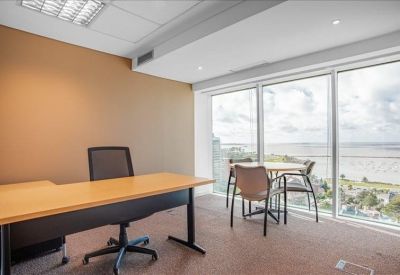 Private corner office with a wooden desk and expansive sea views.