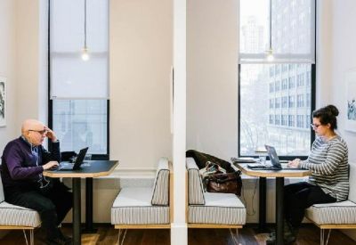 Two semi-private workstations with cushioned bench seating and individual task lighting.