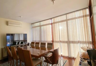 Spacious dining or meeting room with a large wooden table and floor-to-ceiling windows.