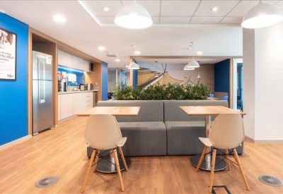 Modern communal kitchen and dining area with blue feature walls.