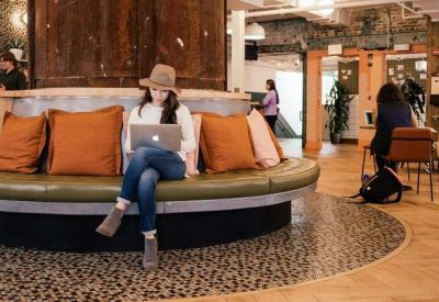 Spacious lounge with a large circular olive green banquette and warm wood paneling at Rua Sergipe, 1440 Belo Horizonte.