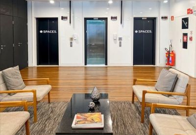 Lounge area with mid-century modern chairs and elevator access.