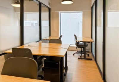 Private office suite with glass walls and minimalist desks.