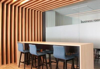Modern high-top table with blue stools set against a feature wall of vertical wooden slats.