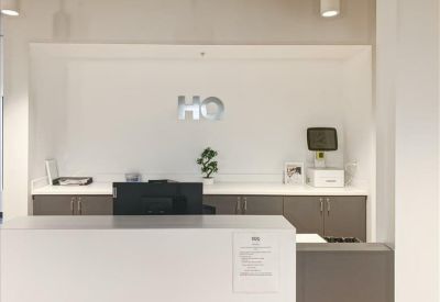 Professional reception desk with white counter and minimalist wall branding.