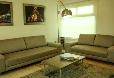 Comfortable lounge area with beige sofas, a wooden coffee table, and warm lighting.