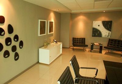 Spacious office interior with leather armchairs and contemporary wall art.