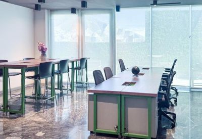 Casual break area with high-top tables, green legs, and polished stone flooring.