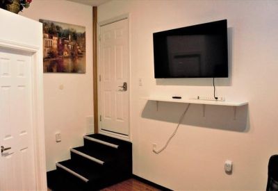 Office interior featuring a small staircase, wall-mounted television, and framed artwork.