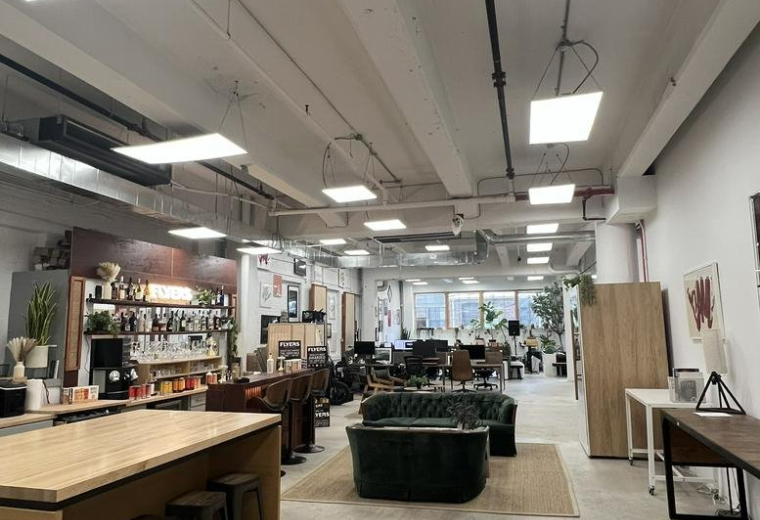 Spacious communal area at Williamsburg Office, Brooklyn with high ceilings, wood accents, and modern lighting.