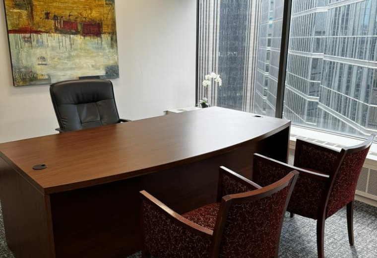 Bright private office at 155 University Avenue, Suite 1800 with a dark wood desk and city views.