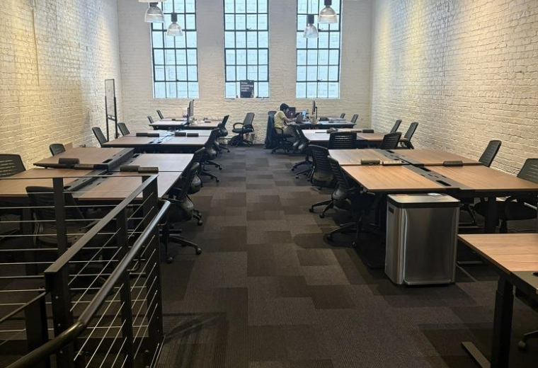 Spacious open-plan workspace at 639, Howard Street with industrial ceilings and rows of desks.