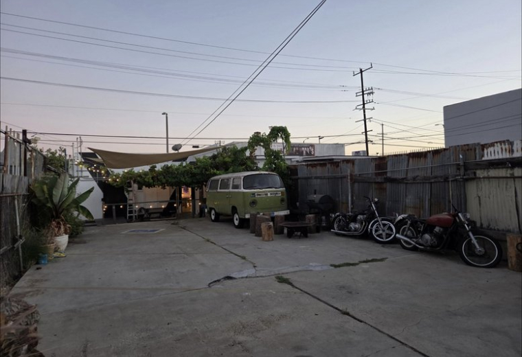 Exterior parking and patio area at 907, West Anaheim Street featuring a vintage green van.
