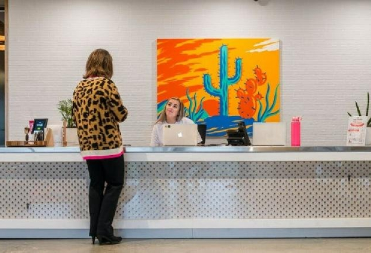 Bright reception desk at Preston Center, 5960 Berkshire Lane featuring a colorful desert cactus mural.