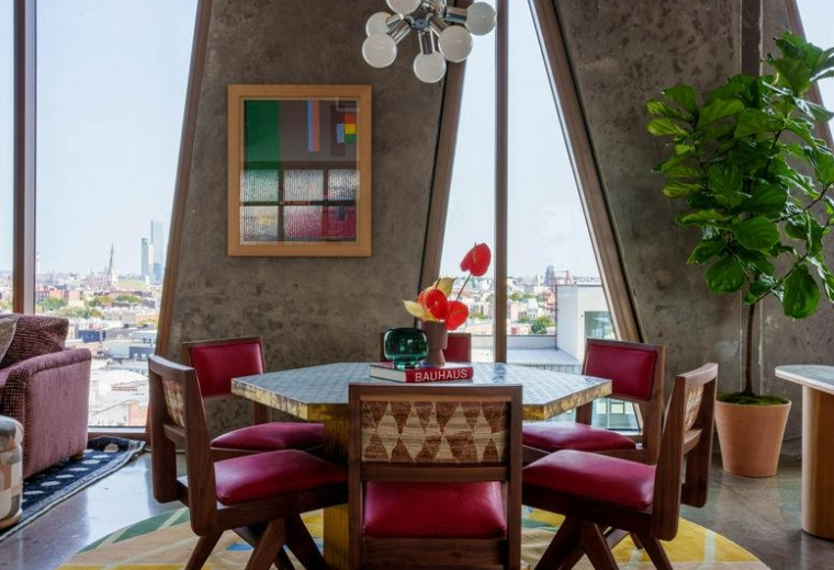 Colorful dining area with a round table and red chairs at 109 North 12th Street, The William Vale.