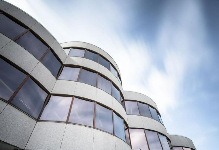 Curved modern exterior of the glass and stone building at 1940 Eglinton Ave E, 4th Floor, Toronto, Ontario.