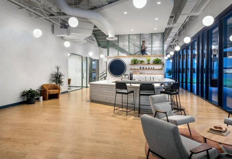 Spacious lounge and cafe at 2500 CityWest Boulevard, Suite 150, with wood floors and modern light fixtures.