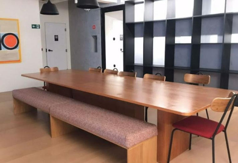 Communal room with a long wooden table and chairs at Market Place building