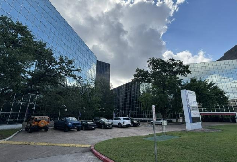 Exterior view of the modern glass-facade building at 1001 West Loop South in Houston.