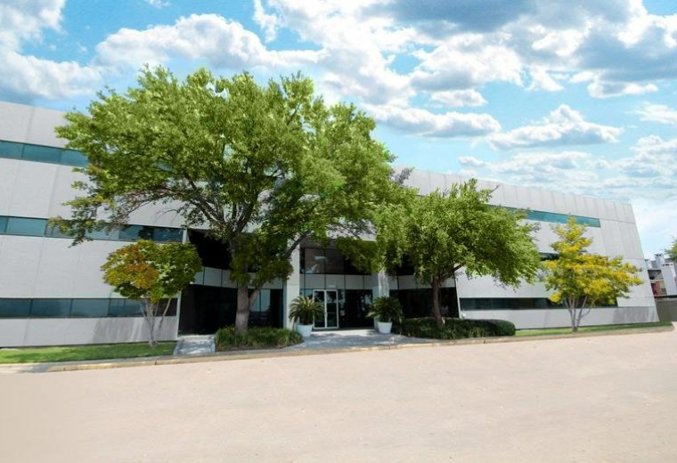 Exterior view of the white facade and landscaped entrance at 10039 Bissonnet Street.