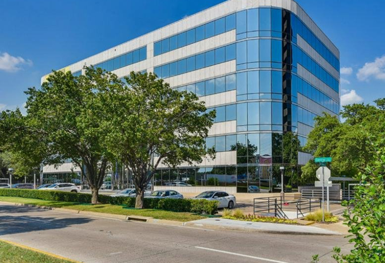 Exterior view of the multi-story glass and stone building at 10100 North Central Expressway.