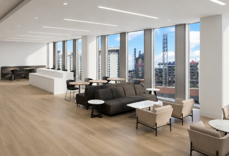 Spacious communal lounge with diverse seating options and views of a stadium at 1100, Circle 75 Parkway, Suite 400.