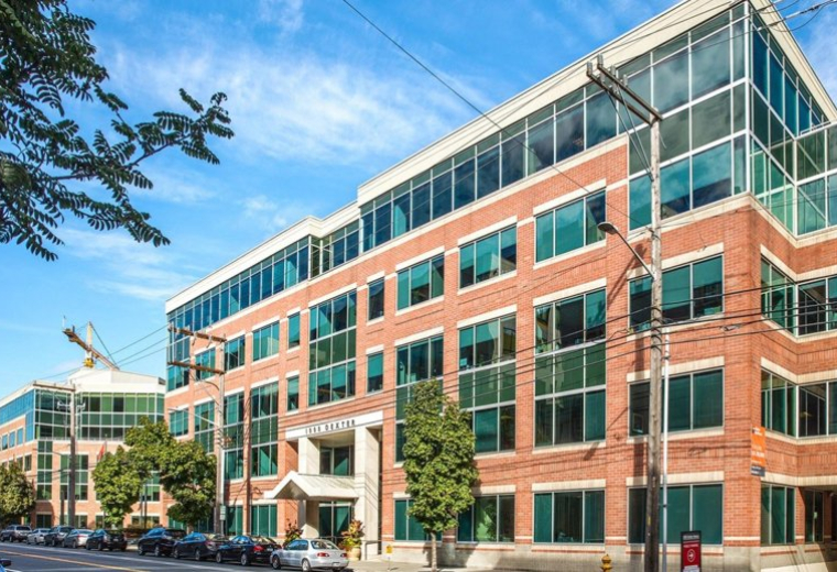 Exterior view of the brick and glass facade of 1100 Dexter Ave N, Suite 100.