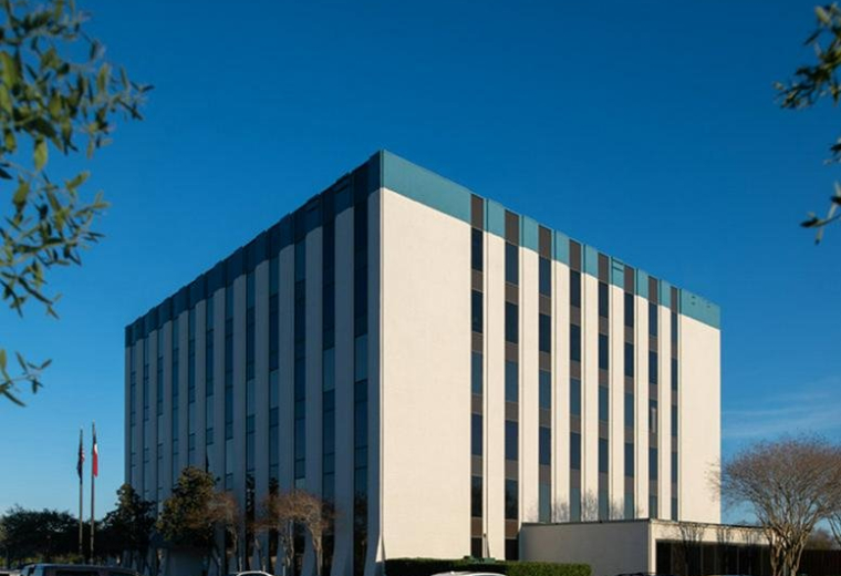Exterior view of the white and blue multi-story office building at 1120 NASA Parkway.