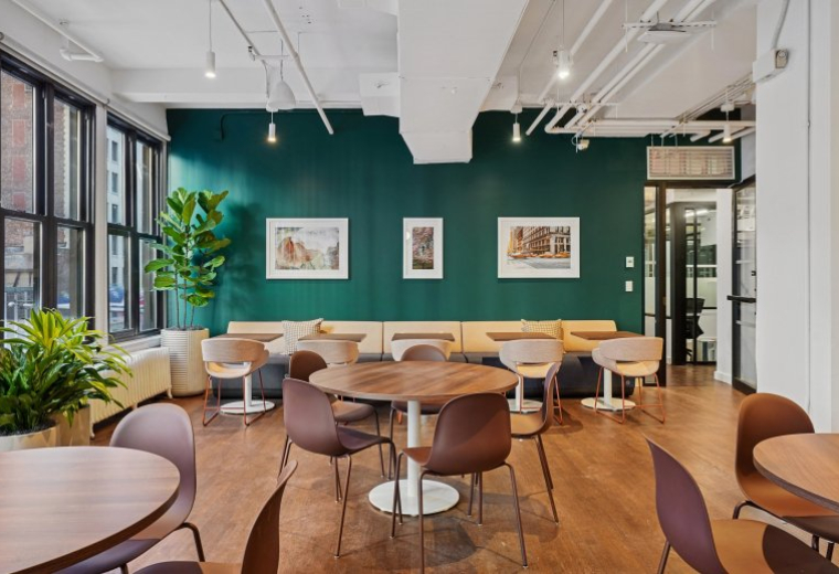 Spacious communal lounge at 120 East 23rd Street, 4th Floor featuring a deep green accent wall and modern seating.
