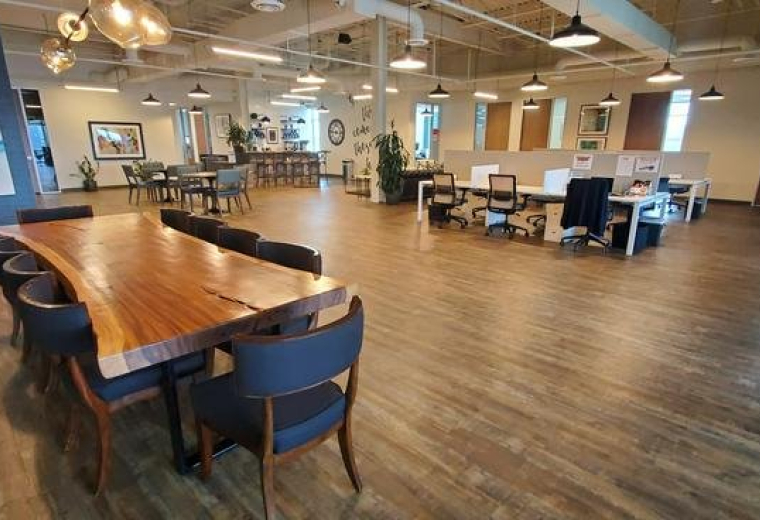 Spacious open-plan common area at 13100 Wortham Center Drive with a large live-edge wood table.