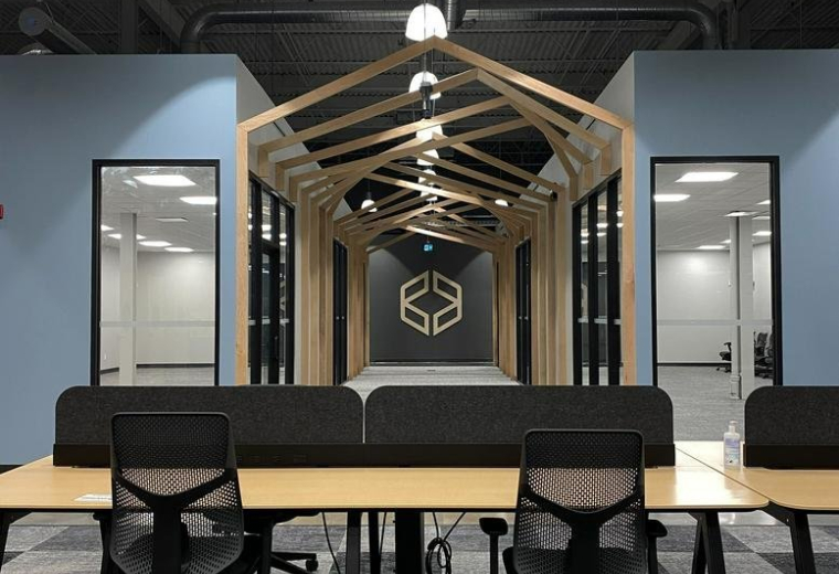 Open-plan office at 137, Glasgow Street, featuring wooden house-frame accents and modern workstations.