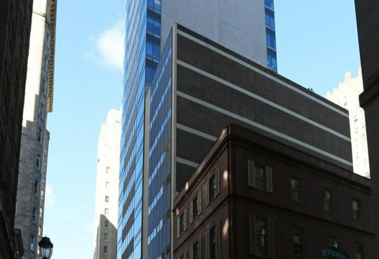 Building facade showing the office structure next to a classic brick building.
