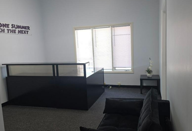 Spacious reception area at 1522 Pointer Ridge Place, A featuring a black front desk and seating.
