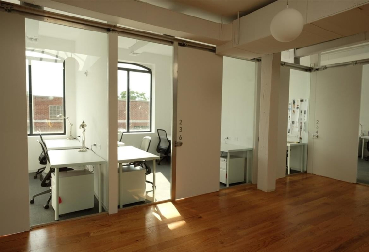 Spacious interior workspace with wooden floors and private glass-partitioned offices at 157 13th Street, Gowanus.