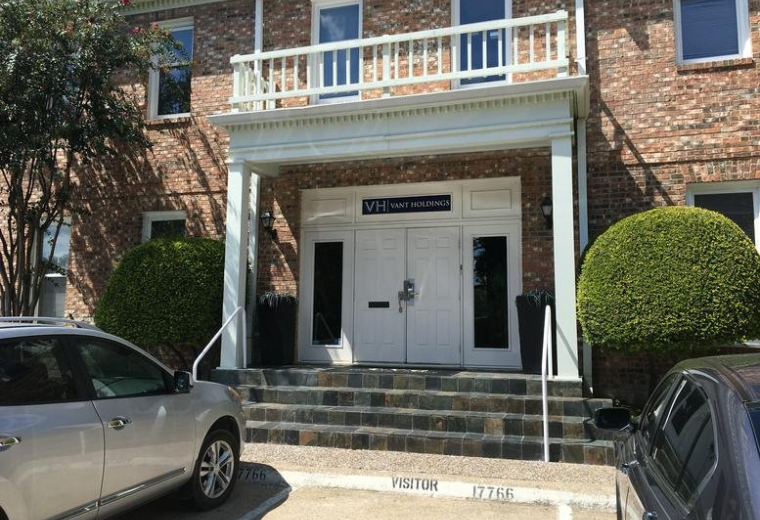 Exterior brick facade of the office building at 17766 Preston Road with white columns and balcony.