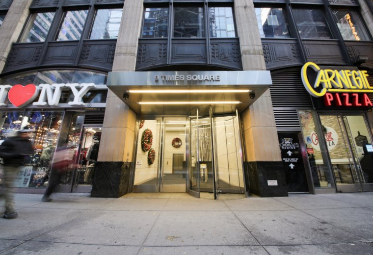 Exterior view of the street-level entrance at 9 Times Square with revolving doors.