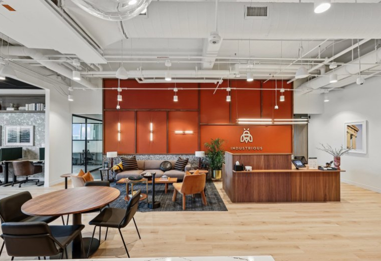 Spacious reception area of 21 Platform Way S, 14th Floor with a wood desk and orange feature wall.