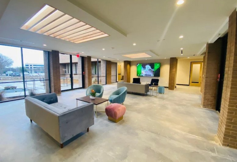 Bright lounge and lobby area at 2100 North Greenville Avenue featuring modern furniture and natural light.