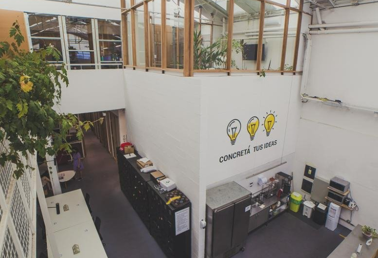 Wide interior view of the modern creative workspace at 2133, Avenida Dorrego with open-plan desks and greenery.