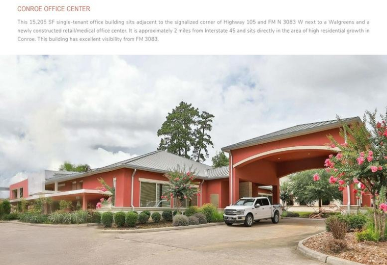 Exterior of the red-brick Conroe Office Center featuring a large covered entryway and landscaping.