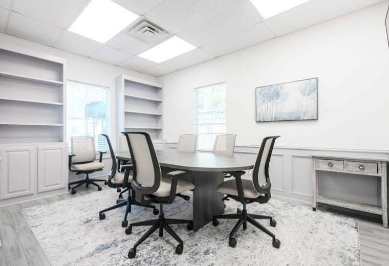 Meeting room at 22206, Highland Knolls Drive with a dark wood table, mesh chairs, and a plush patterned rug.