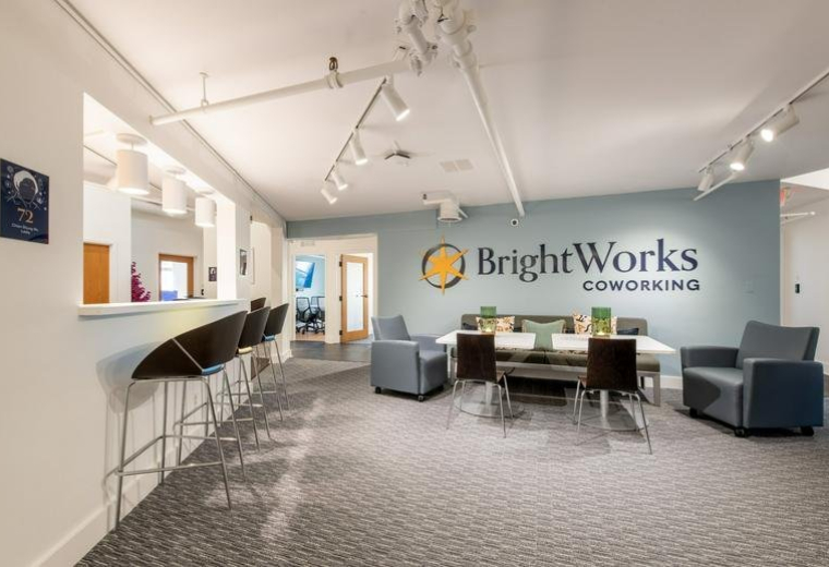 Spacious reception and lounge area at BrightWorks Coworking with modern furniture and branded wall.
