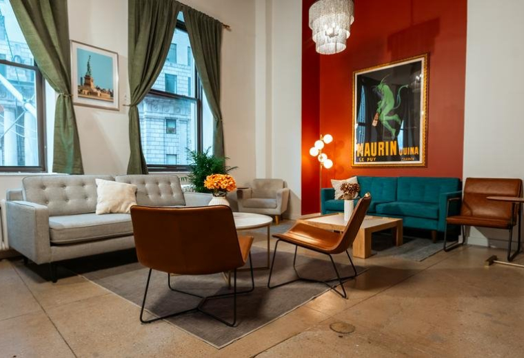 Stylish lounge area at 26 Broadway with a red accent wall and mid-century modern furniture.