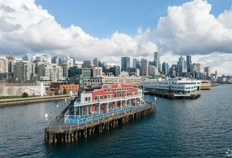 Exterior view of the red and white pier building at 2801 Alaskan Way Suite 201 over the water.