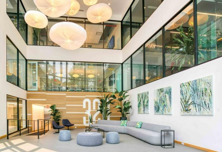 Large multi-level atrium with modern grey seating and spherical light fixtures.