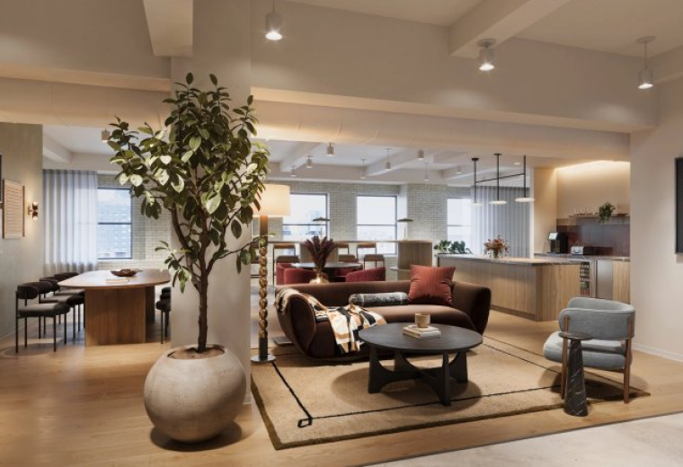 Spacious communal lounge at 386 Park Avenue South, 18th Floor featuring a velvet sofa, large plant, and kitchen area.