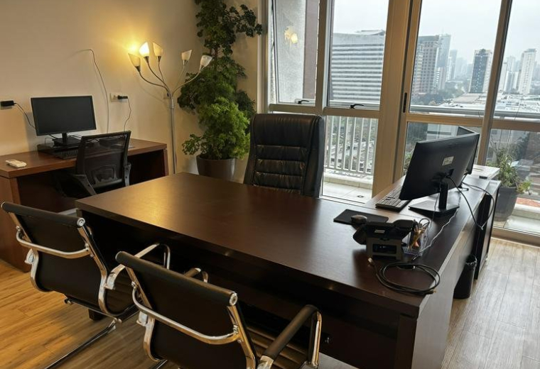 Private executive office at 472, Rua Enxovia with large wooden desk and city views.