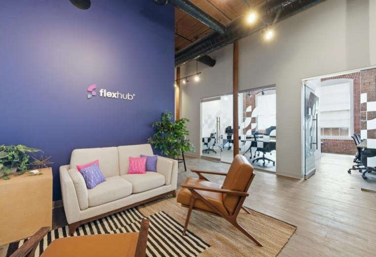 Reception lounge at 500 North Commercial Street featuring a blue feature wall and modern white sofa.