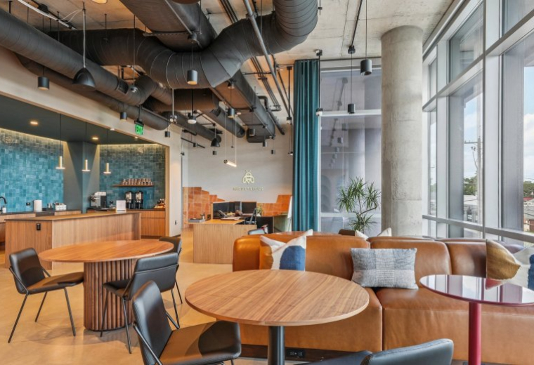 Spacious communal lounge at 5209 Burnet Road, Suite 200 with leather sofas and industrial ceiling.